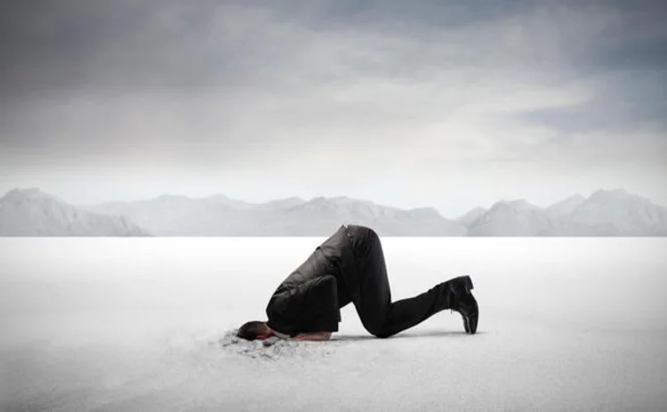 A businessman with his head in the sand